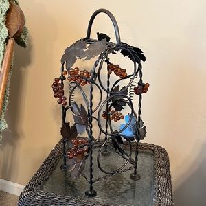 Metal wine bottle rack with glass grape accents.